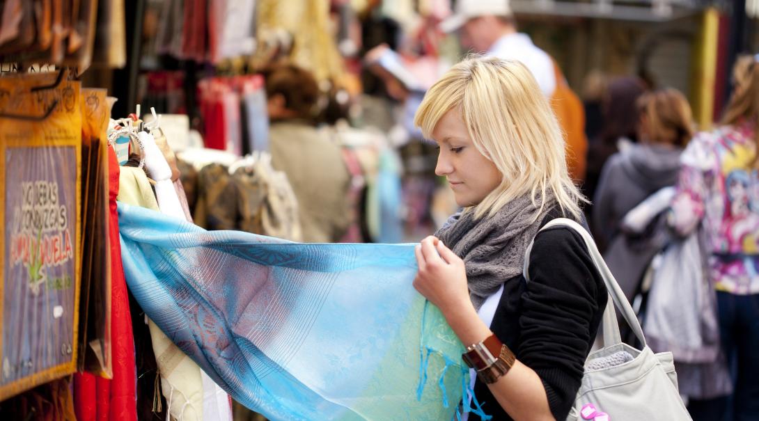 A participant explores a local market as part of her ethical consumerism project abroad. Woman learns about ethical consumerism on a trip abroad.